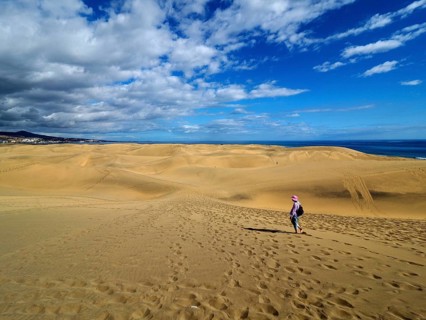 Wide sand dune landscape with a hiker under the blue sky, dunes of Maspalomas, Gran Canaria, Canary