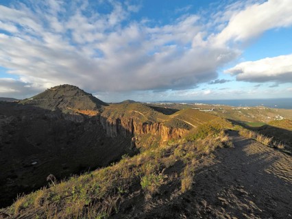 Range of hills under extended sky, widely visible sea in the background, Caldera de Bandama