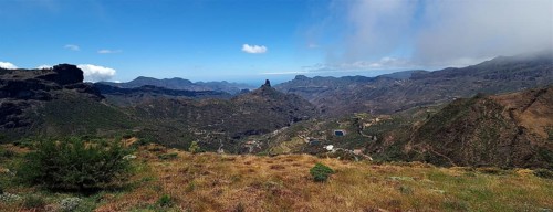 Wide mountain landscape with valley and cloudy sky in the distance. View from Cruz de Tejeda, Gran