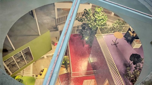 View of the colorful, modern courtyard of a building with plants and different levels, Tirana,