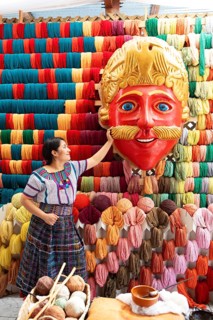 Maya woman, 42 years old, looks at the mask of a Moro or Moor for the traditional mask dance,