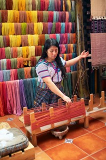 Maya woman, 42 years old, places cotton in a weaving frame, traditional craft in a woman's