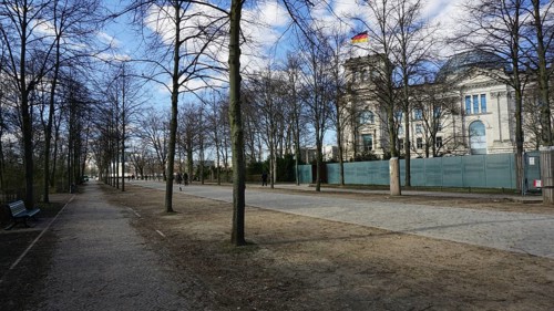 Promenade along the Reichstag with trees and sidewalk on a sunny day, deserted, without people,