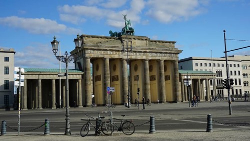 Famous gate in Berlin, Brandenburg Gate with a few bicycles in the foreground and blue sky,