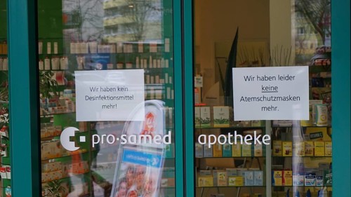 Pharmacy entrance with signs about missing disinfectants and protective masks, during corona,