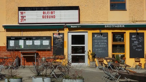 Small café with outdoor seating area and menu boards when the sun is shining with stays healthy and