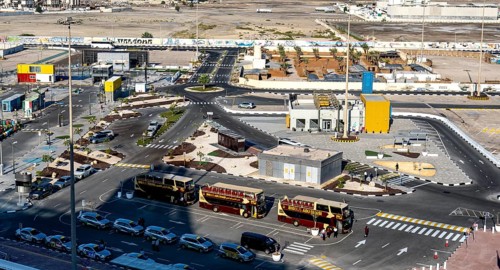 Taxi and hop on hop off buses are waiting for tourists in the cruise terminal parking lot, Abu