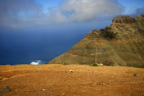 Rocky cliff with a cross in the ground, sea and clouds in the background, Mirador de Ermita de Las