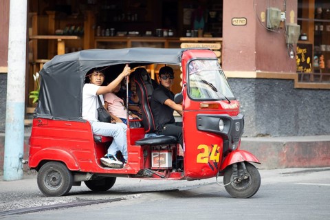 Red tuk tuk or tricycle taxi with Guatemalan passengers in Panajachel, Atitlán, Sololá Department,