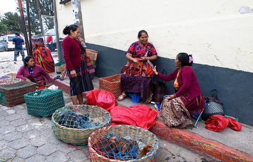 Mayan woman wearing traditional clothing sell chickens on the street in Chichicastenango,