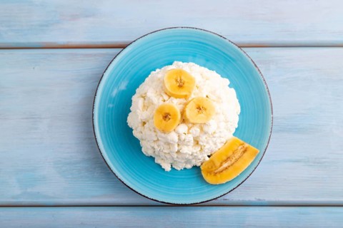 White ?ottage cheese, Curd, with Banana on blue wooden background, top view, flat lay, close up