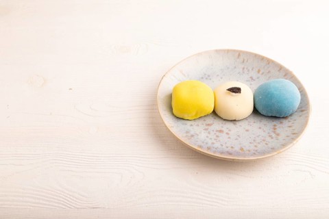 Japanese Mochi Cakes on white wooden background, side view, copy space