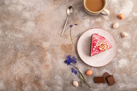 Chocolate cake on brown concrete background, cup of coffee, top view, flat lay, copy space