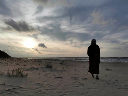 A person standing on the beach looking at the sea at sunset, atmospheric scene, Baltic Sea, fresh