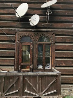 Rustic wooden house with old windows and several satellite dishes, High Tatras, Poland