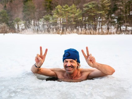 Man with cap, 55, ice bathing in an ice hole makes the Victory sign with both hands, Thumsee, Bad