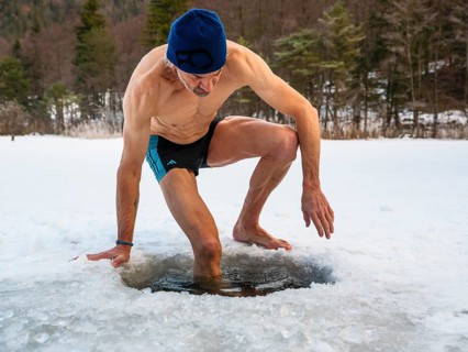 Man with cap, 55, climbs into an ice hole for ice bathing, Thumsee, Bad Reichenhall,