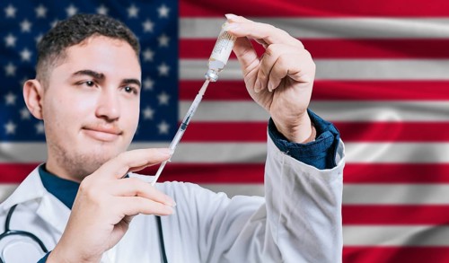 Doctor holding syringe on United States flag background. Medical professional holding syringe with