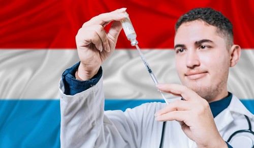 Doctor holding syringe on Luxembourg flag background. Medical professional holding syringe with