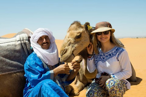 Young woman with Berber and dromedaries in the sand dunes, near Merzouga, Meknès-Tafilalet region,