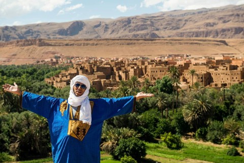 Traditionally dressed Berber and Allas Mountains in the background, near Merzouga, Meknès-Tafilalet