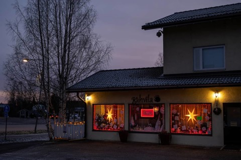 Christmas decorated and illuminated shop window with poinsettias and fairy lights, blue hour,