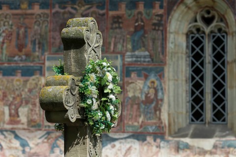 Artificial flower wreath on a stone cross in front of the Romanian Orthodox Women's Monastery,