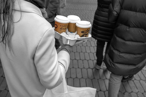 Lady carrying three coffees to go on the street, black and white, Nuremberg, Middle Franconia,