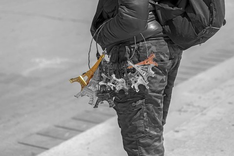 Street vendor with Eiffel Tower souvenirs on his arm, black and white, Paris, France