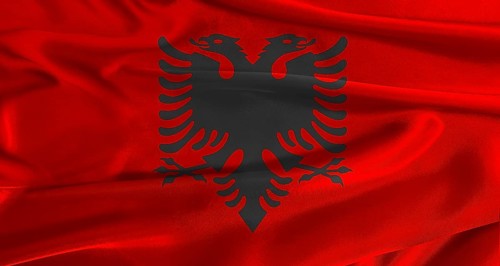 Flag of Albania with fabric textured background. Close up of National flag of Albania with