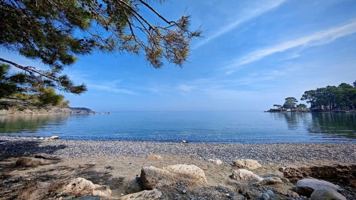 A peaceful pebble beach with a view of the calm sea and clear skies, Antalya, Turkey