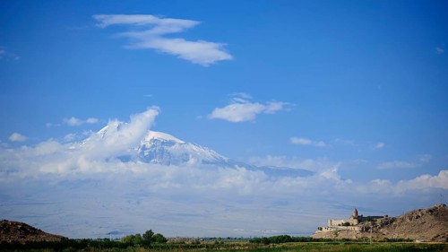Extensive mountain landscape with a small monastery and cloudy sky, Khor Virap with Ararat in the