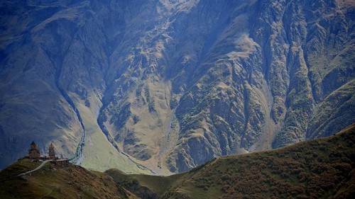 Picturesque mountain slopes with church on a hill in daylight, Gergeti Monastery, Georgia