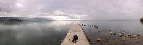 Long footbridge leads into a vast lake surrounded by peaceful countryside, Lake Ohrid, North