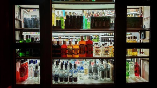 Diverse selection of liquor bottles on illuminated shelves, Prague, Czech Republic