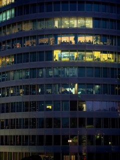 Night view of illuminated office building with visible floors and lights, Tirana, Albania