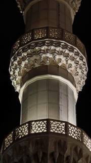 Detailed view of an illuminated minaret with intricate ornaments at night, Tirana, Albania