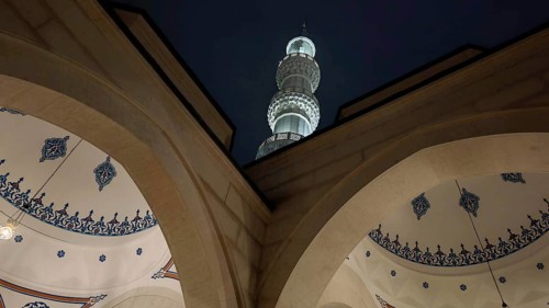 Night view of a mosque with minaret and ornamental arches, Tirana, Albania