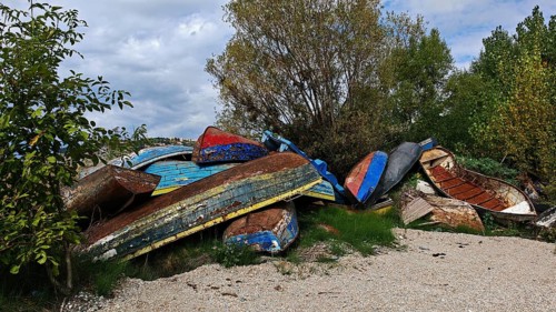 Abandoned, colorful boats are piled up in a natural environment, North Macedonia