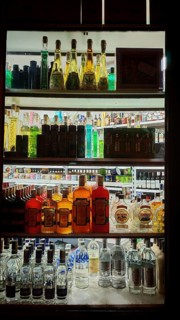 Bottles of various spirits on an illuminated shelf, Prague, Czech Republic