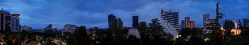 Panoramic view of a skyline at dusk with skyscrapers and trees, Tirana, Albania