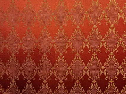 Red fabric with golden, ornamental damask pattern