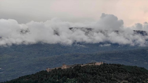 A castle is high up in the wooded mountains surrounded by clouds, North Macedonia