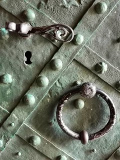 Close-up of an old green door with metal handle and key opening