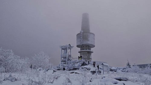 People in snowy surroundings with tower in fog as a central point, Backoefele on the Schneeberg,