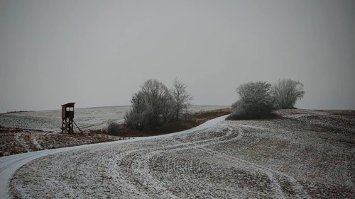 Cold winter day with a snowy dirt road and raised chair, Franconian Forest nature park Park