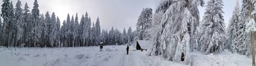 Snowy forest with hut and two people under cloudy sky, Rennsteig, Thuringian Forest