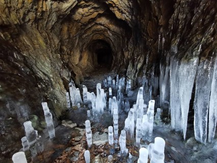 Ice cave with ice stalactites, icicles on rocky walls create a cold, mystical atmosphere,