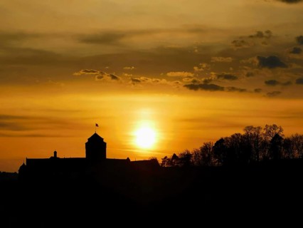 Silhouette of a castle in front of a glowing sunset