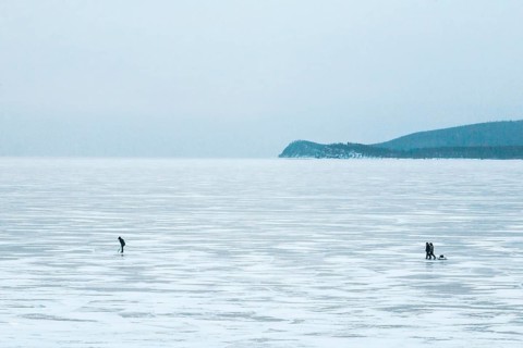 Lake Baikal, Siberia, Russia. People in the vast frozen lake in deep winter